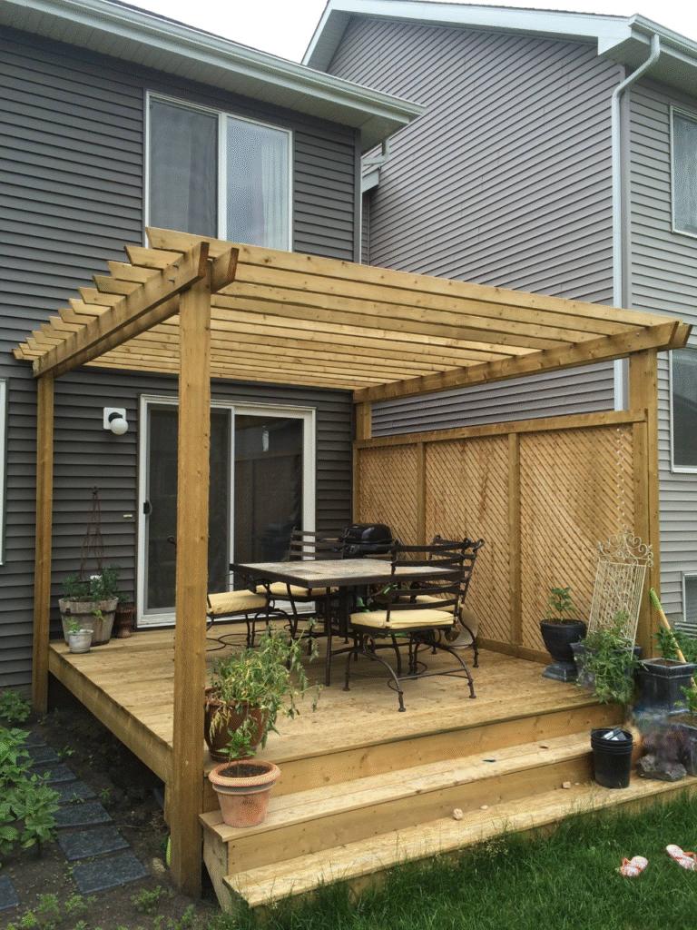 Wooden pergola and deck attached to a house with outdoor furniture.