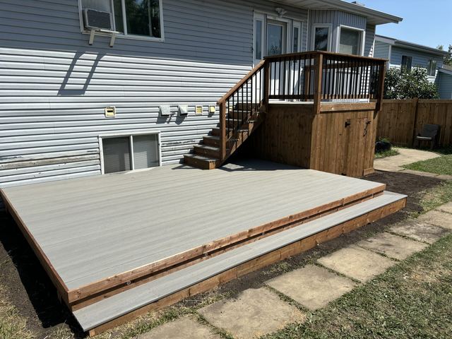 Newly built wooden deck with stairs and railing.