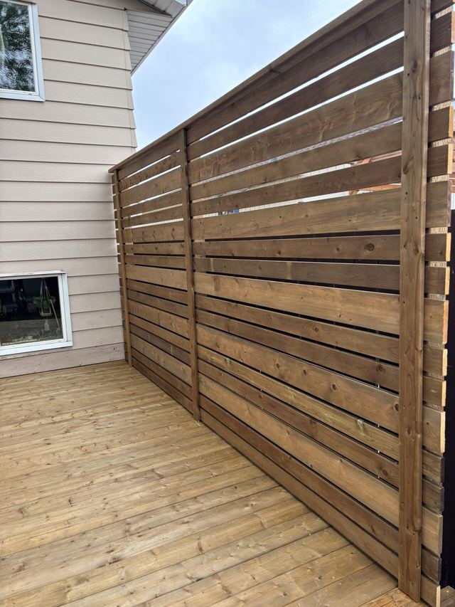 Newly installed wooden privacy fence on a deck.