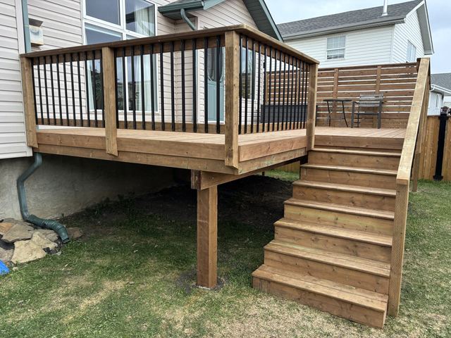 Wooden deck with stairs attached to a house.
