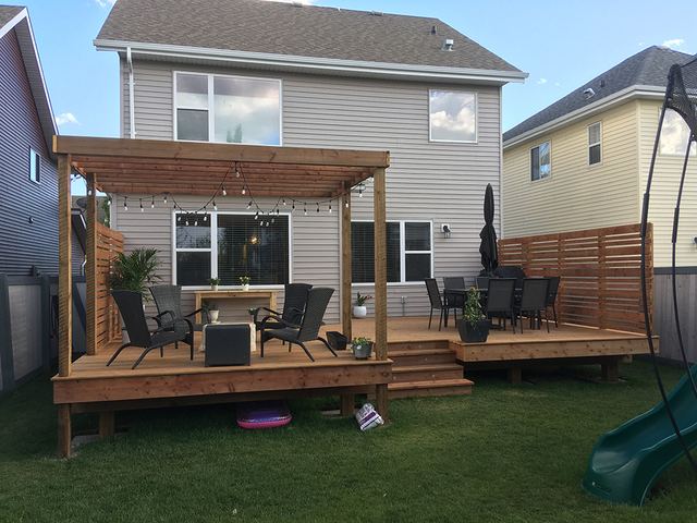 Backyard deck with seating and pergola.