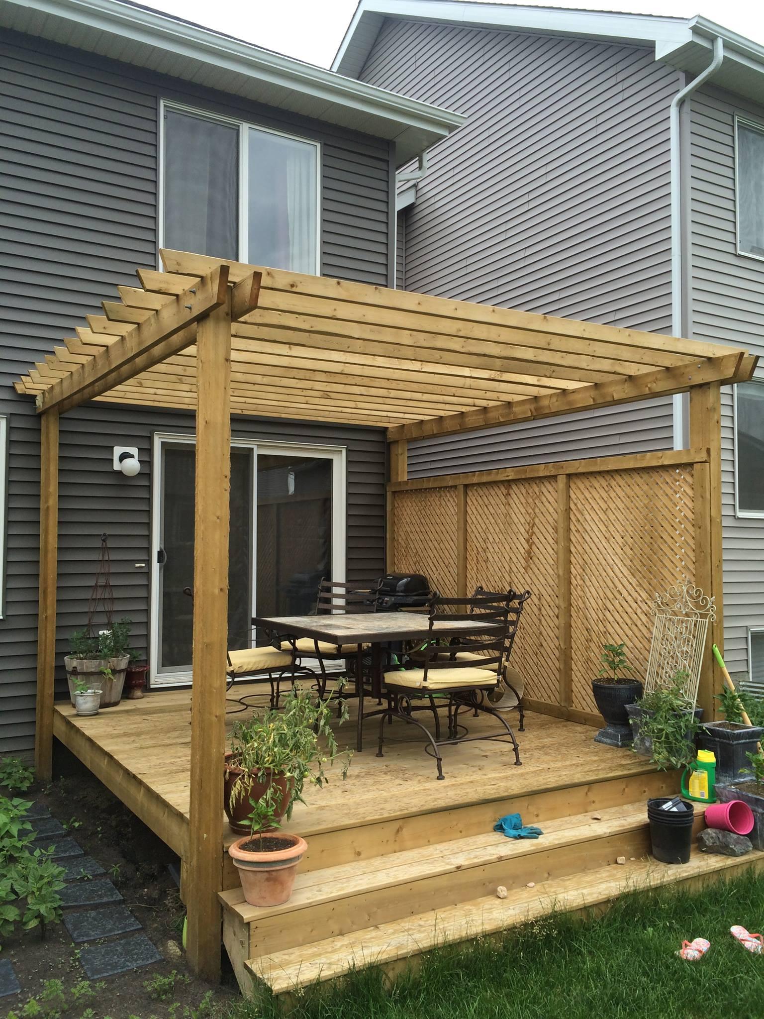 Wooden pergola with outdoor dining set on a deck.