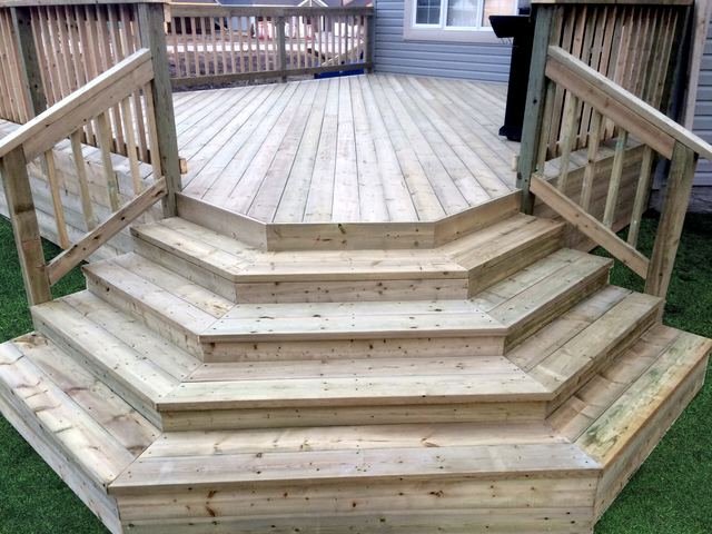 Newly built wooden deck with wide stairs and railings.