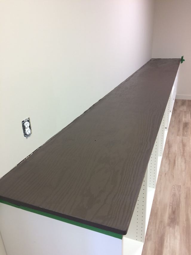 Newly installed dark wood countertop against a white wall.
