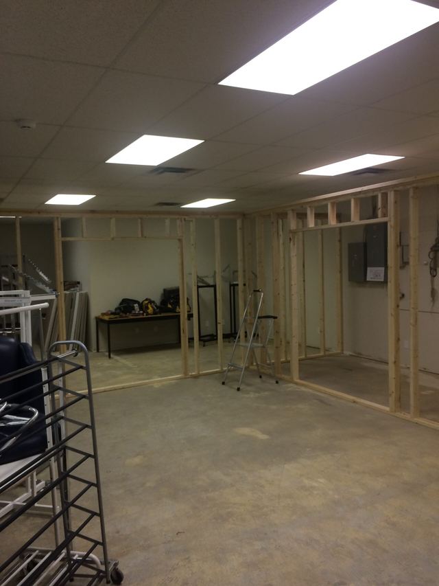 Interior space under renovation with exposed wooden framing and construction materials.
