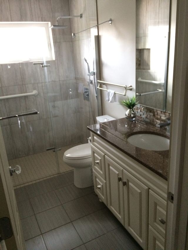 Bright and clean bathroom with a shower, toilet, and vanity sink.