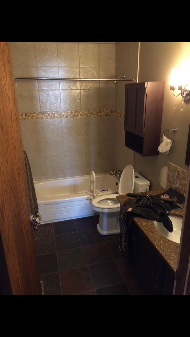 Small bathroom with bathtub, toilet, and sink.