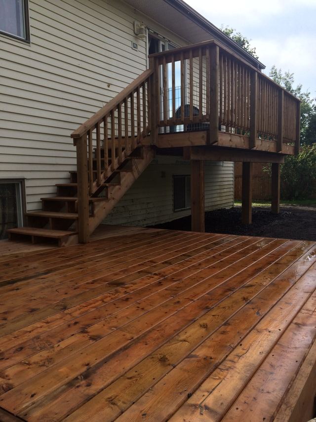 Newly built wooden deck with stairs leading to a raised deck area.