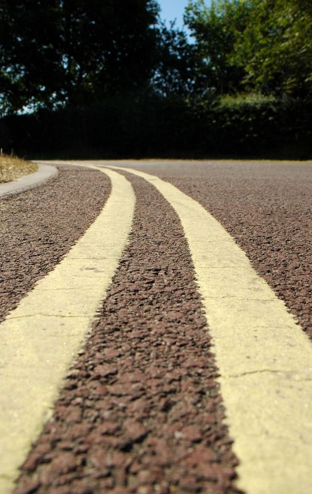 Close-up of double yellow lines on an asphalt road.