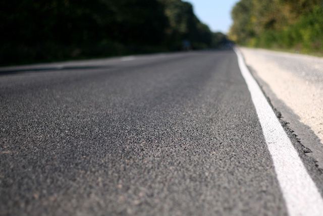 Close-up of a smooth asphalt road with a white edge line.