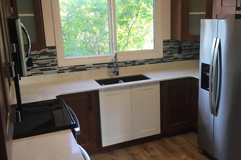 Modern kitchen with dark wood cabinets and a large window above the sink.