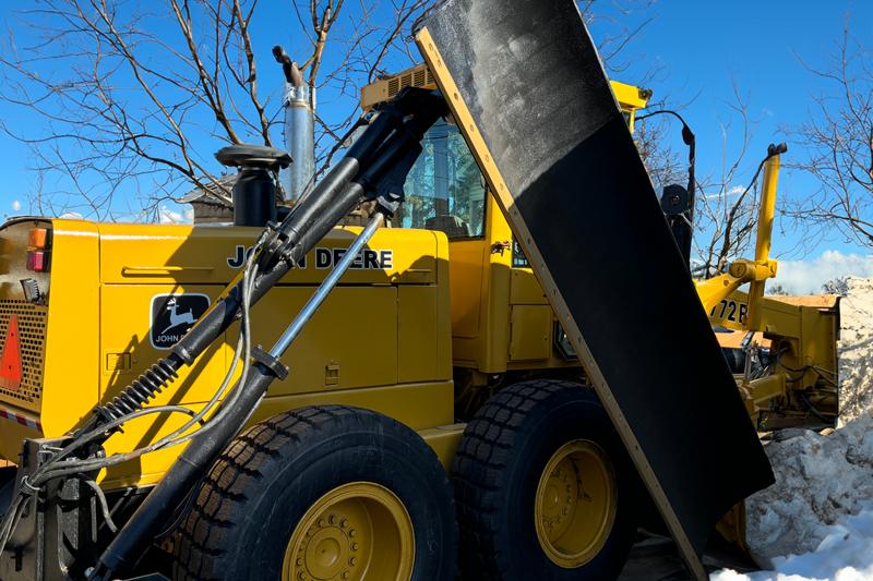 Close-up of a yellow heavy-duty construction vehicle with hydraulic components.